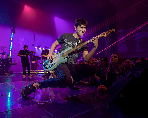 Concert photography of bass guitarist kneeling