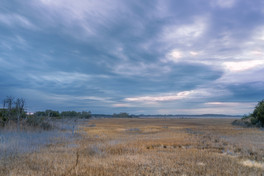 Clouds at sunset over the vast golden Henlopen marsh.