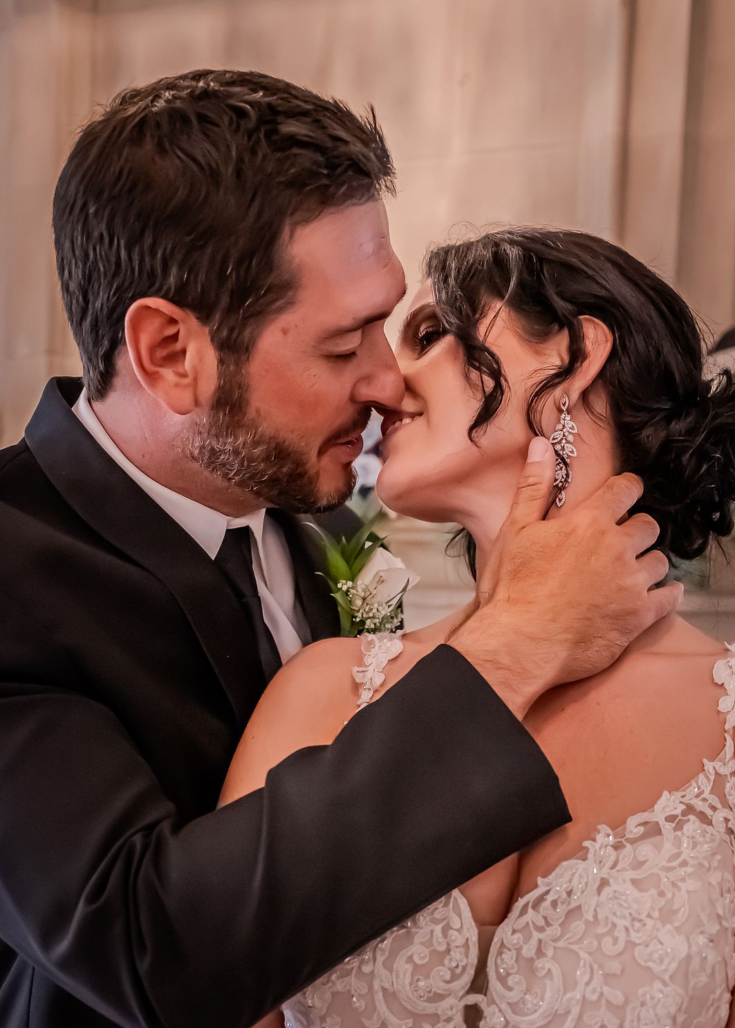 Newly married couple embraces for a kiss.