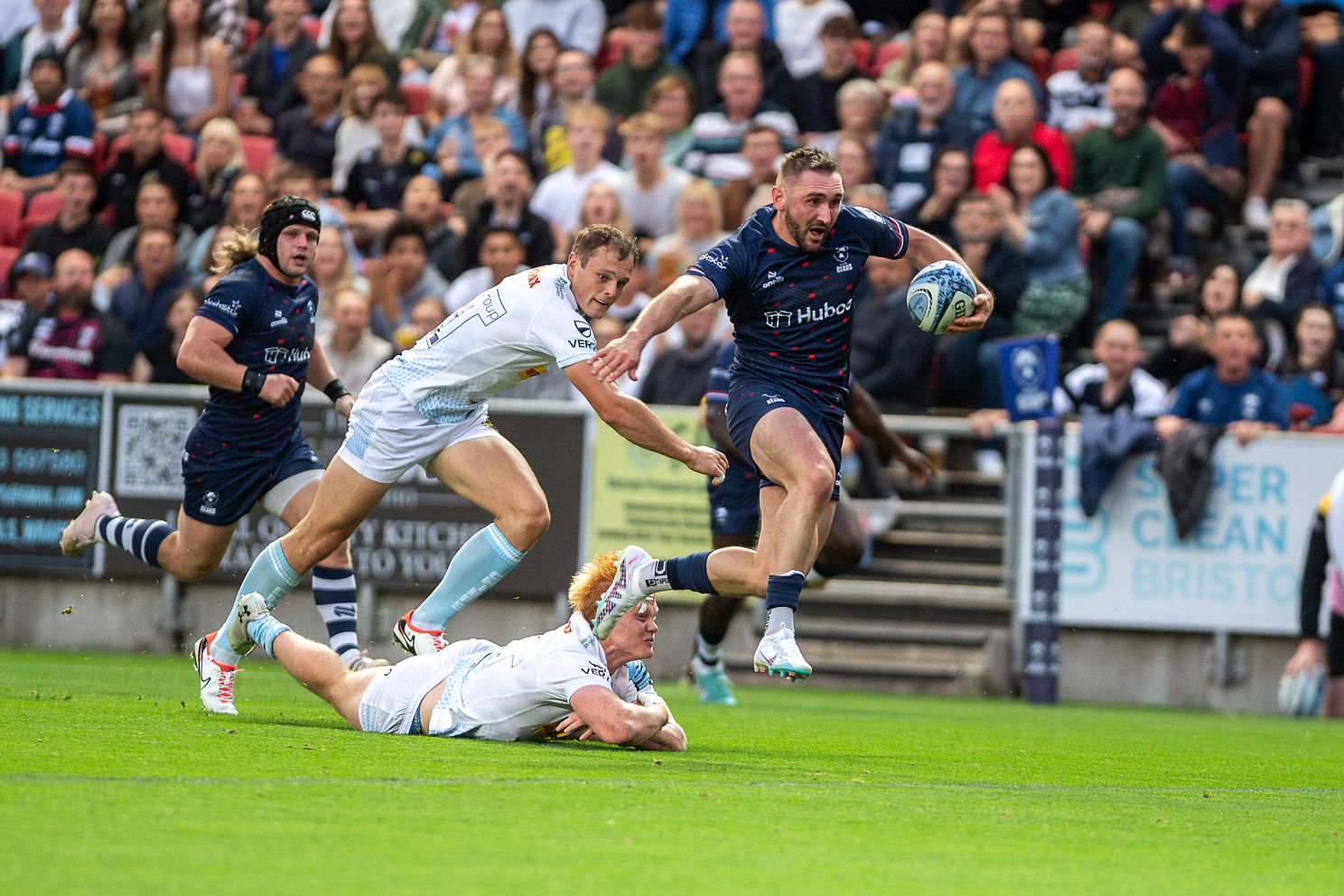 Rugby action: Bristol Bears player evades tackles in thrilling match against Exeter Chiefs.