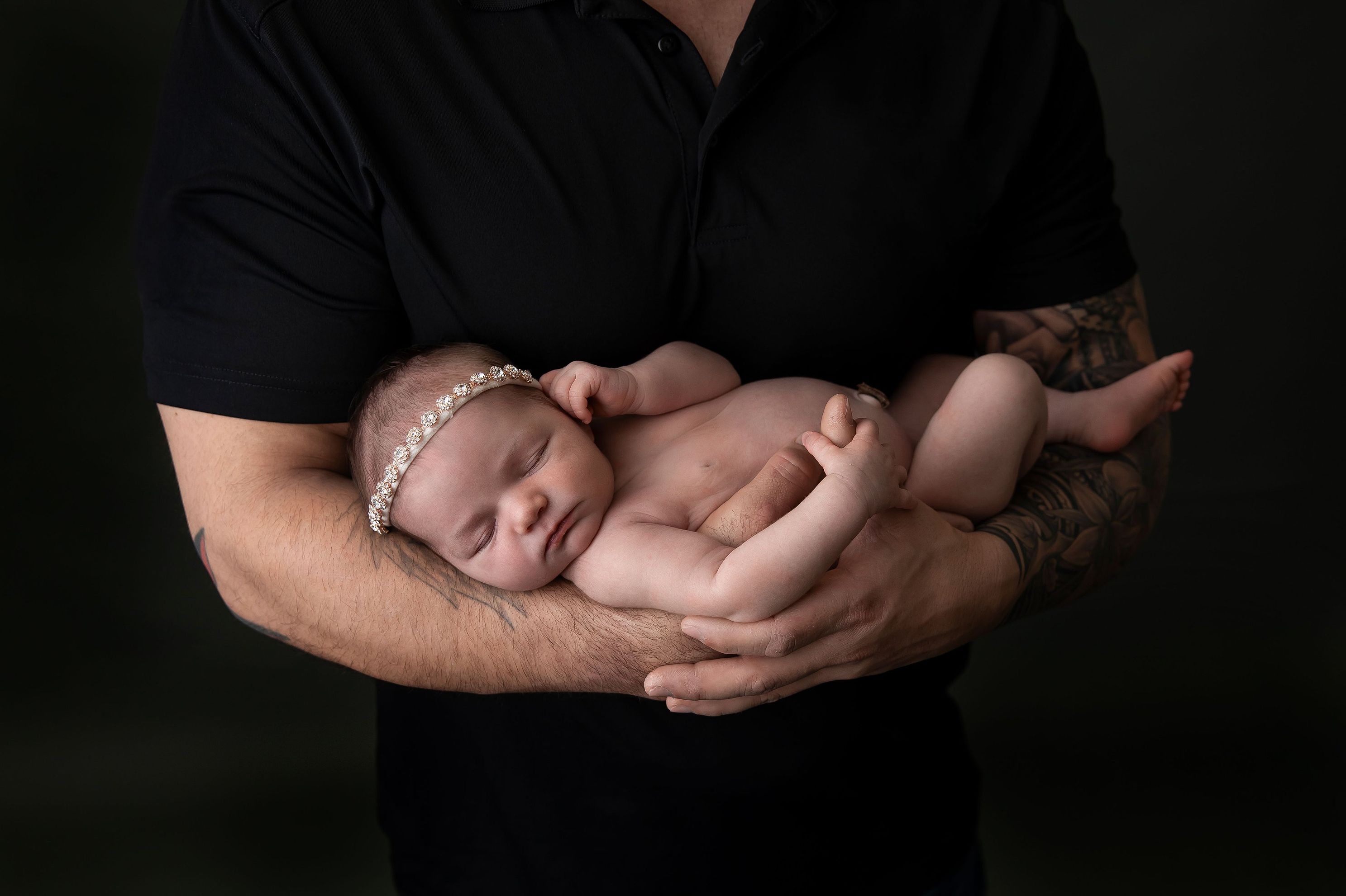 Dad with Black t-shirt and newborn baby girl 13 days with Father. Newborn naked with headband