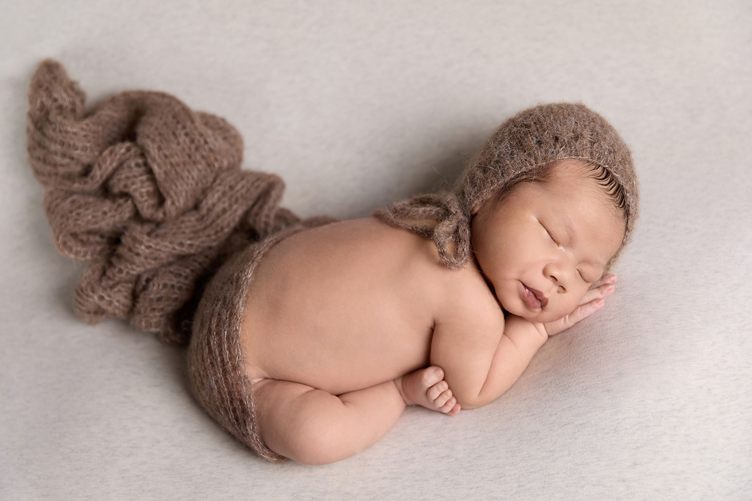 Brown mohair wrap with matching bonnet. Newborn baby boy in womb position, in home studio