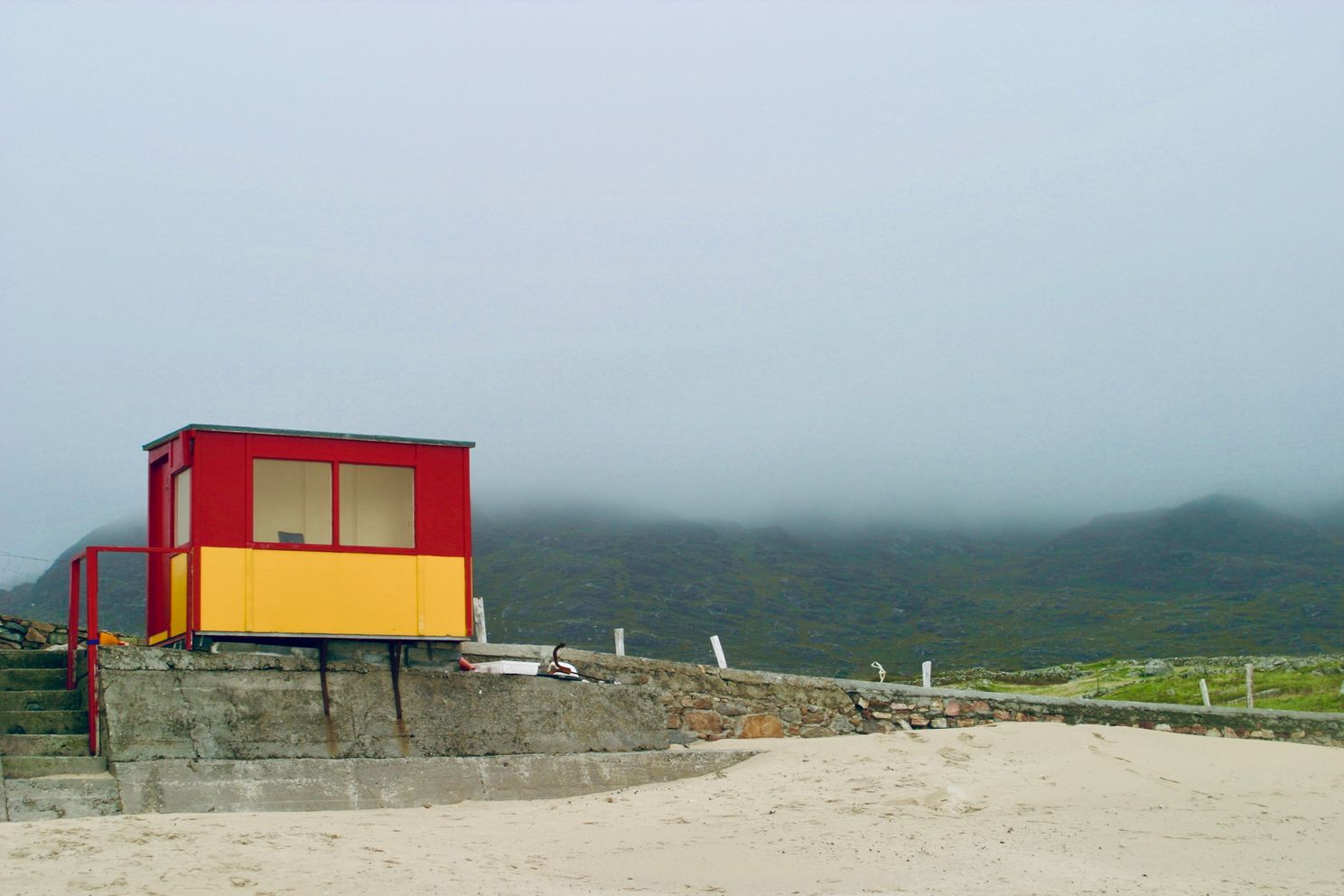 Red & yellow coast guard hut, sandy beach, cloudy sky, Galway Ireland