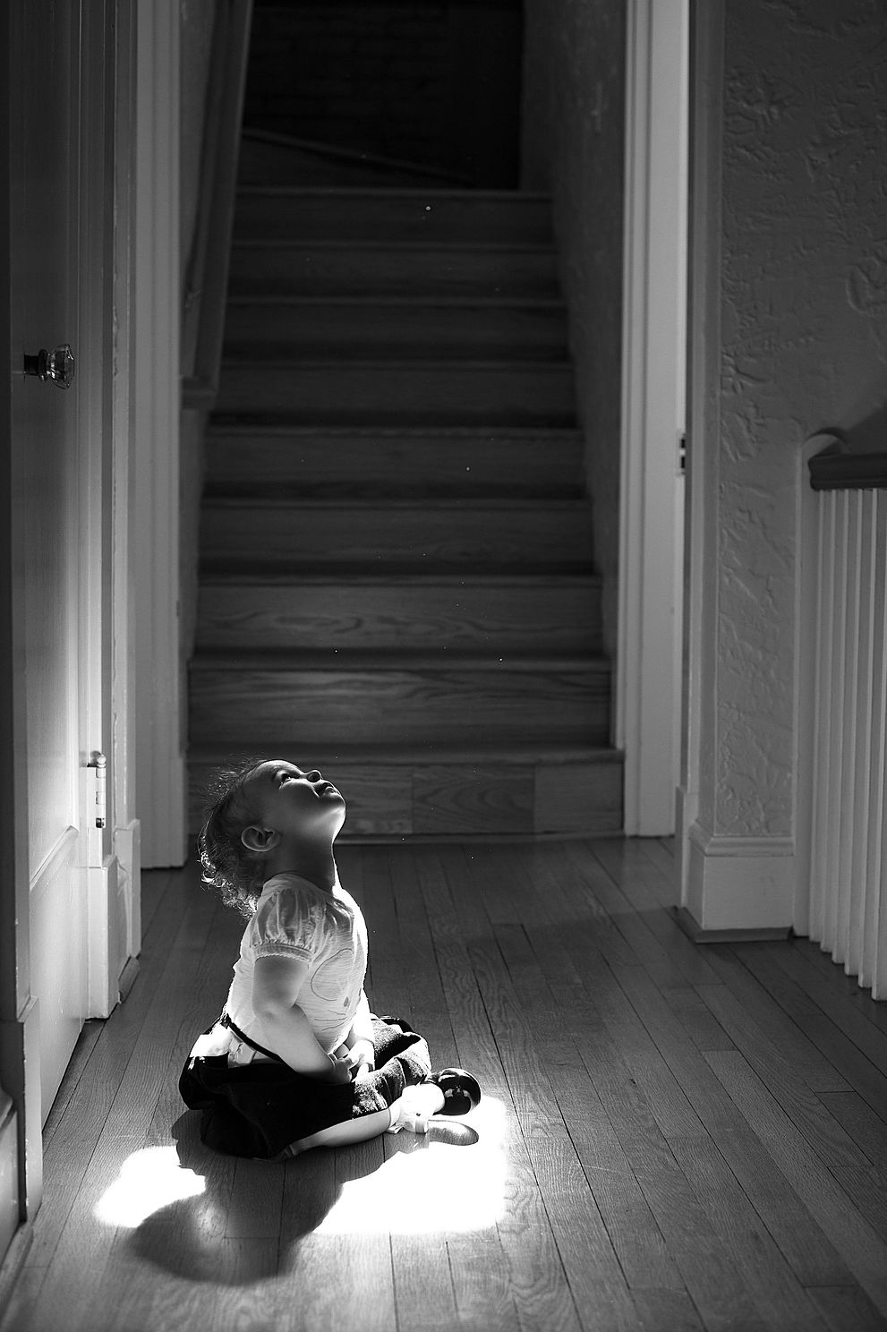 Baby sitting in ray of sunlight black and white