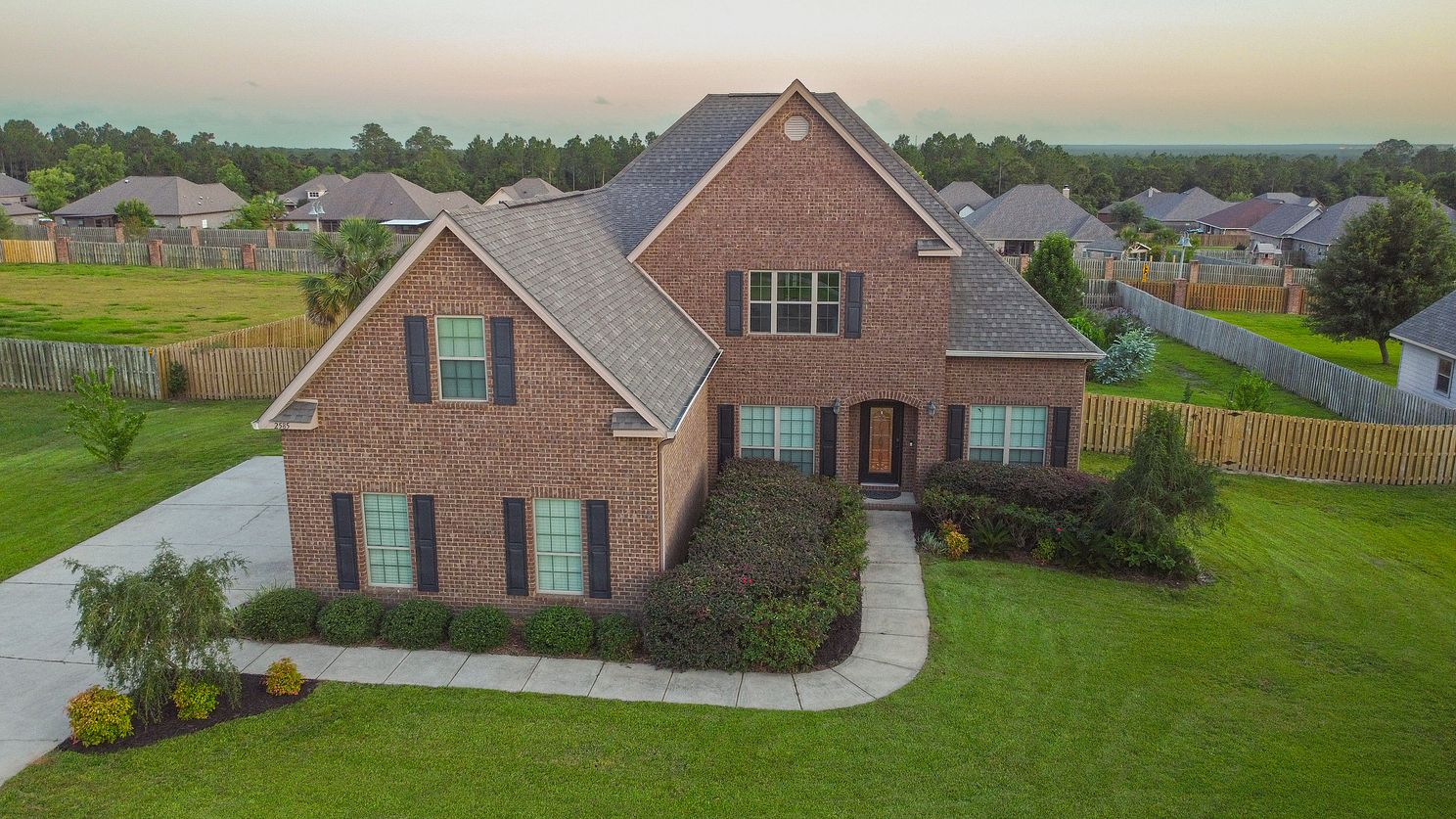 Overhead front drone view of a beautiful brick home