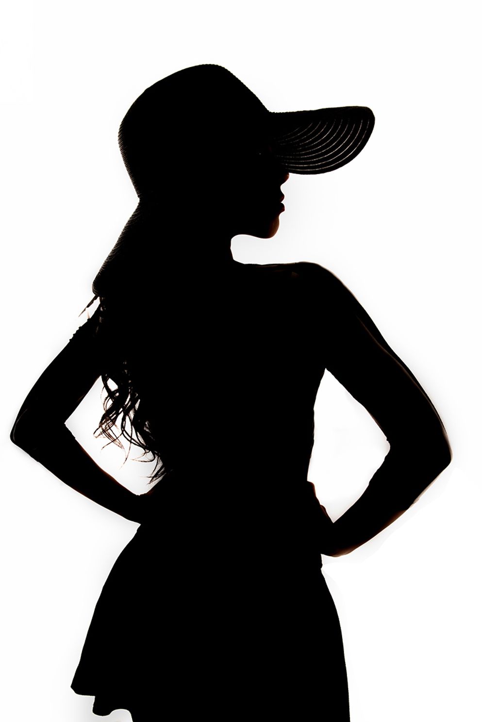 perfect silhouette of a woman wearing a hat with her back facing the camera looking off to the side