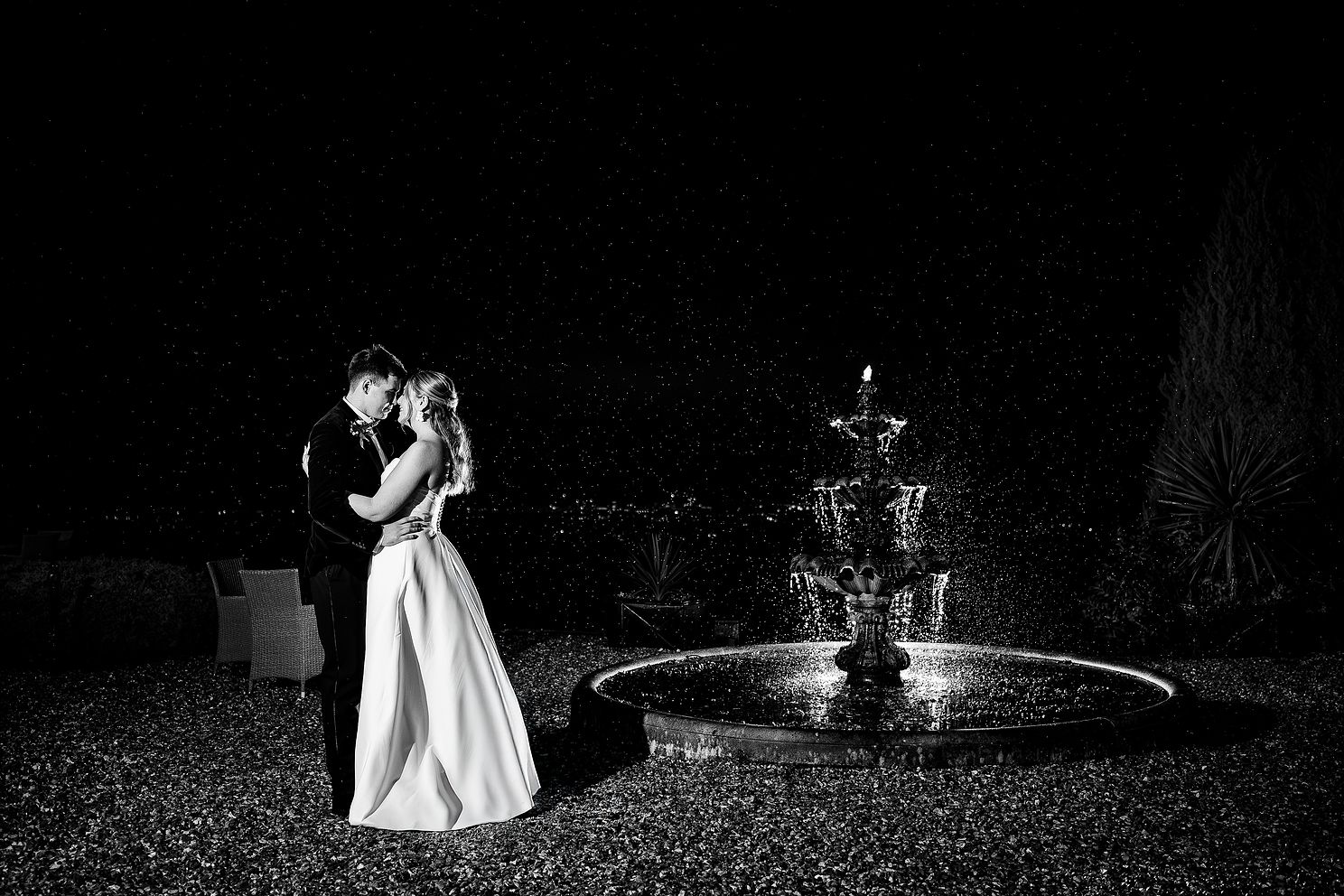 Wedding photographer Peter Morgan with a wedding couple at New House Hotel in front of fountain.