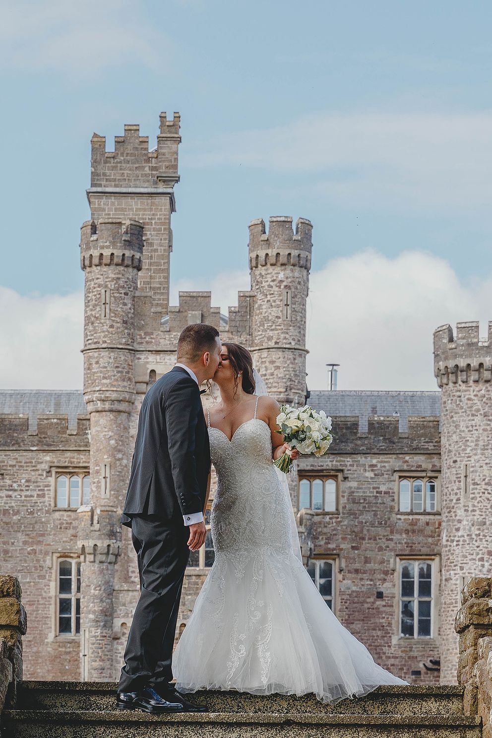 Wedding couple at Hensol Castle in front of the venue.