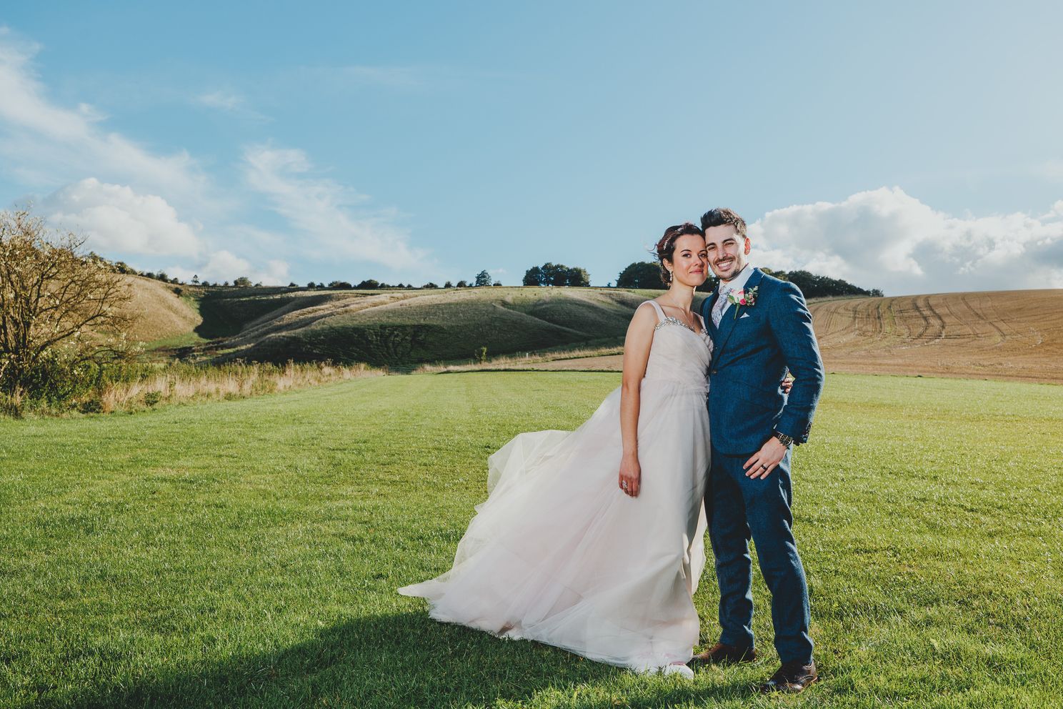 Wedding photographer Peter Morgan with a wedding couple in the fields behind Wellington Barn