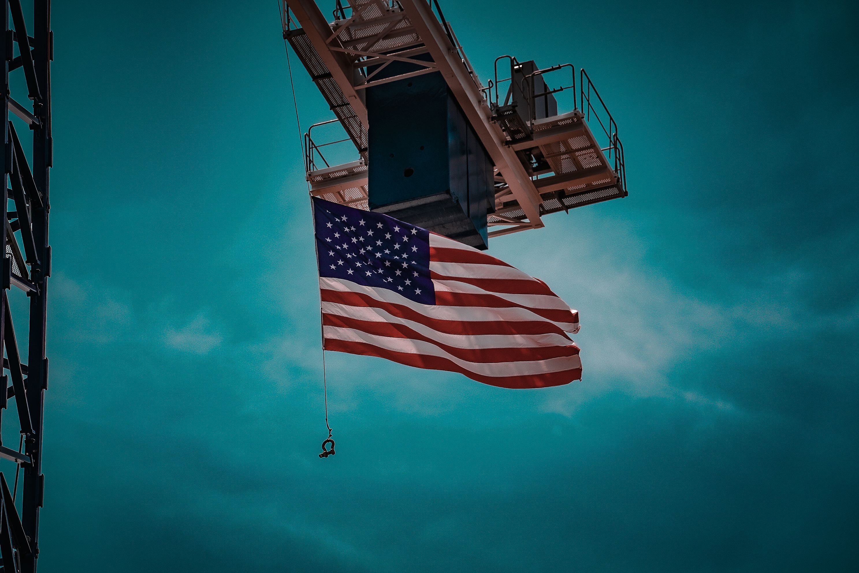 US flag flying high below a crane