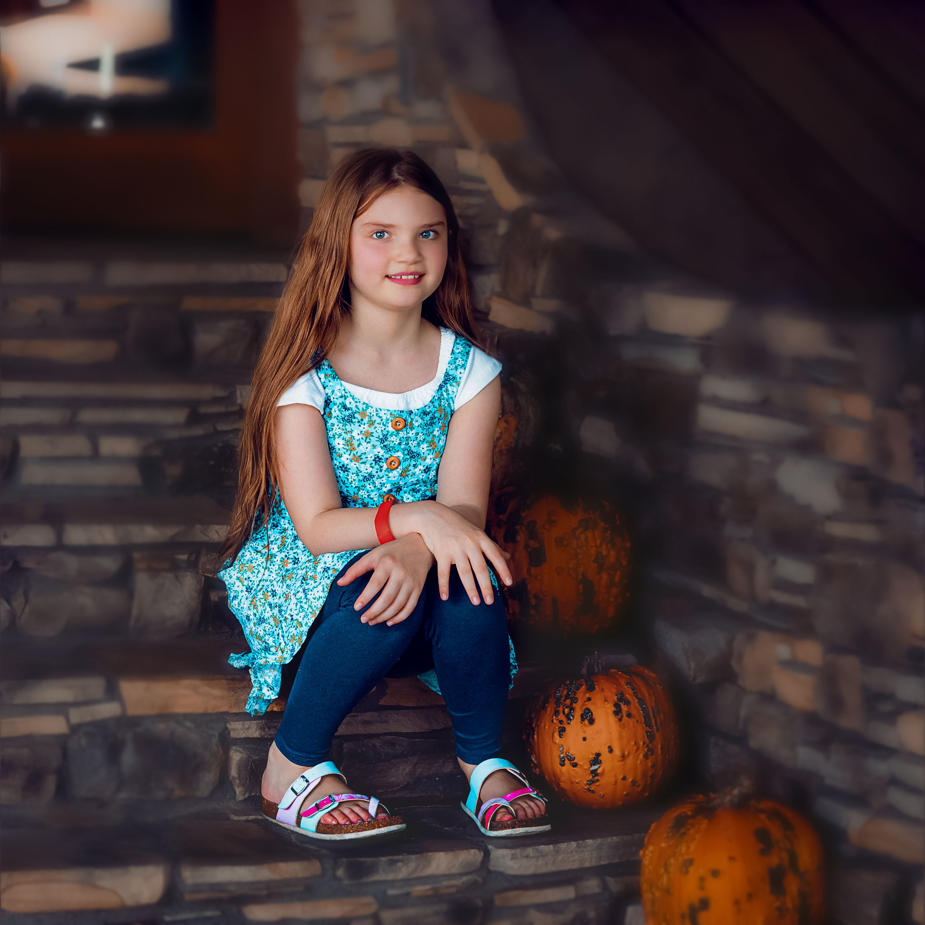 Daughter sitting on steps next to a display of pumpkins