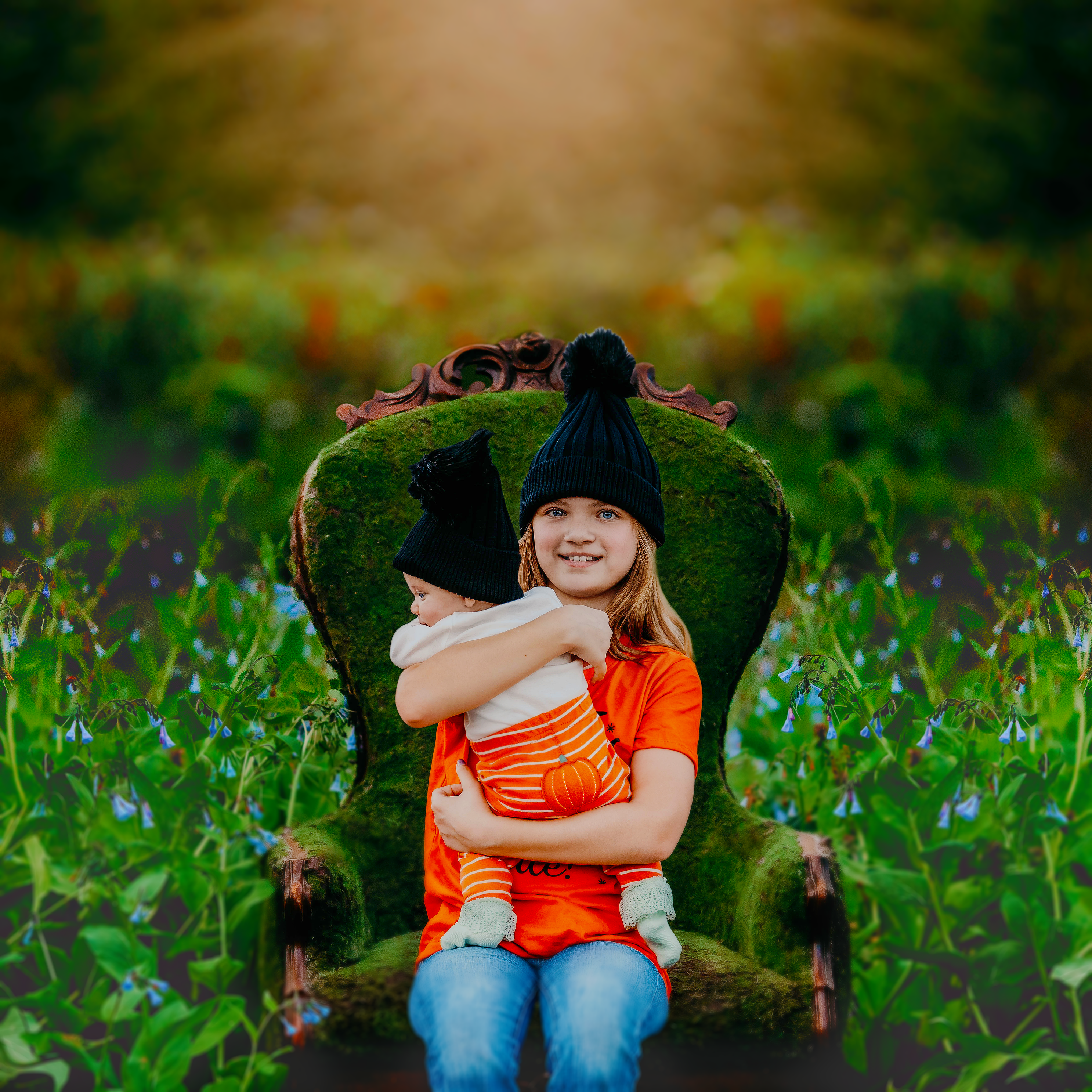 Two sisters sitting in a moss chair in a field