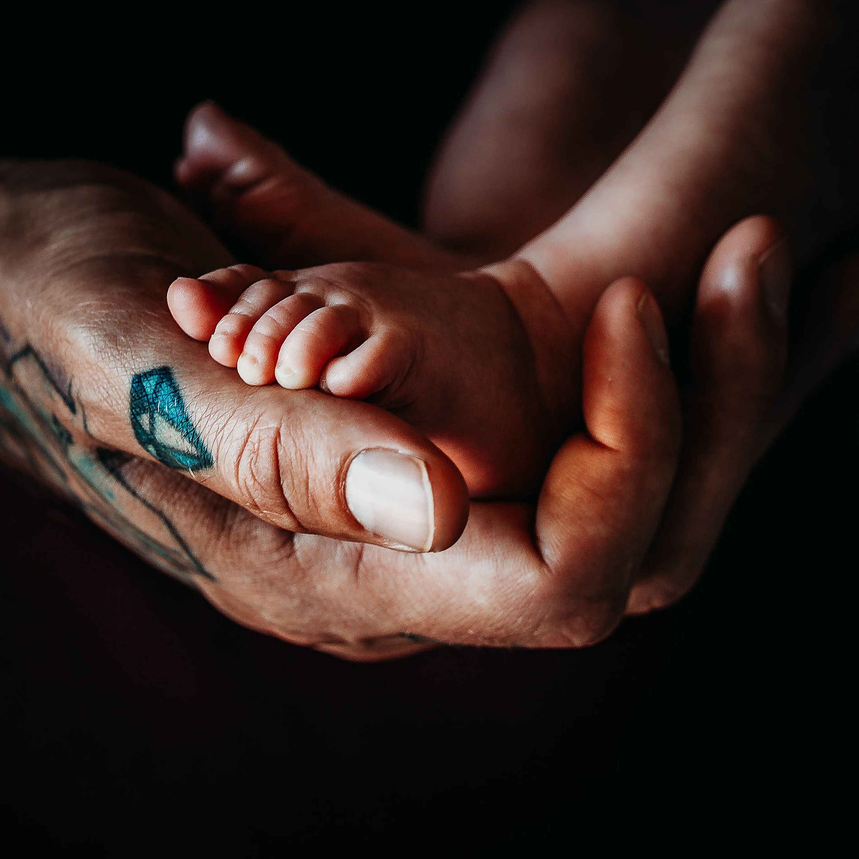 Babies feet in fathers hands
