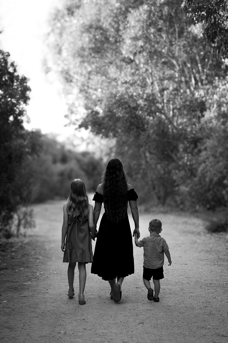 Mother walking with children on nature trail, artistic black and white family portrait Perth