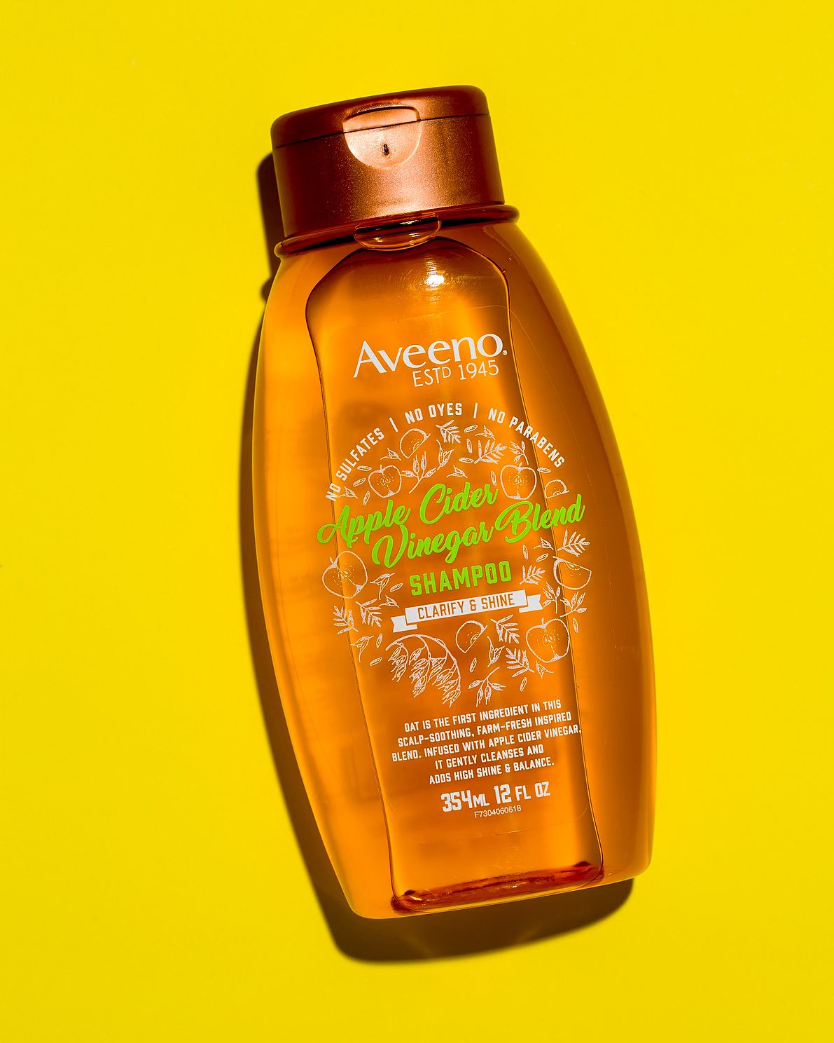 Aveeno apple cider vinegar blend shampoo on yellow background
