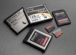 Assorted camera memory cards, including CompactFlash, on a dark surface, ready for data recovery