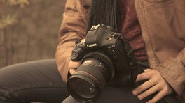 Canon EOS-1D camera with 24-70mm lens resting on a person’s lap.