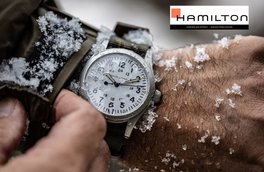 Snow-covered wristwatch with white dial on rugged strap