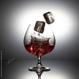 Glass of liquor with ice mid-air