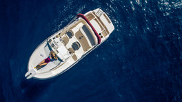 Drone view of luxury boat with person sunbathing on deck