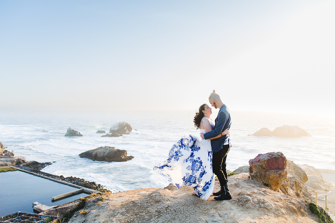 A couple in the wind on the cliffs above Sutro Baths in San Francisco.  Shot by ShootAnyAngle.com