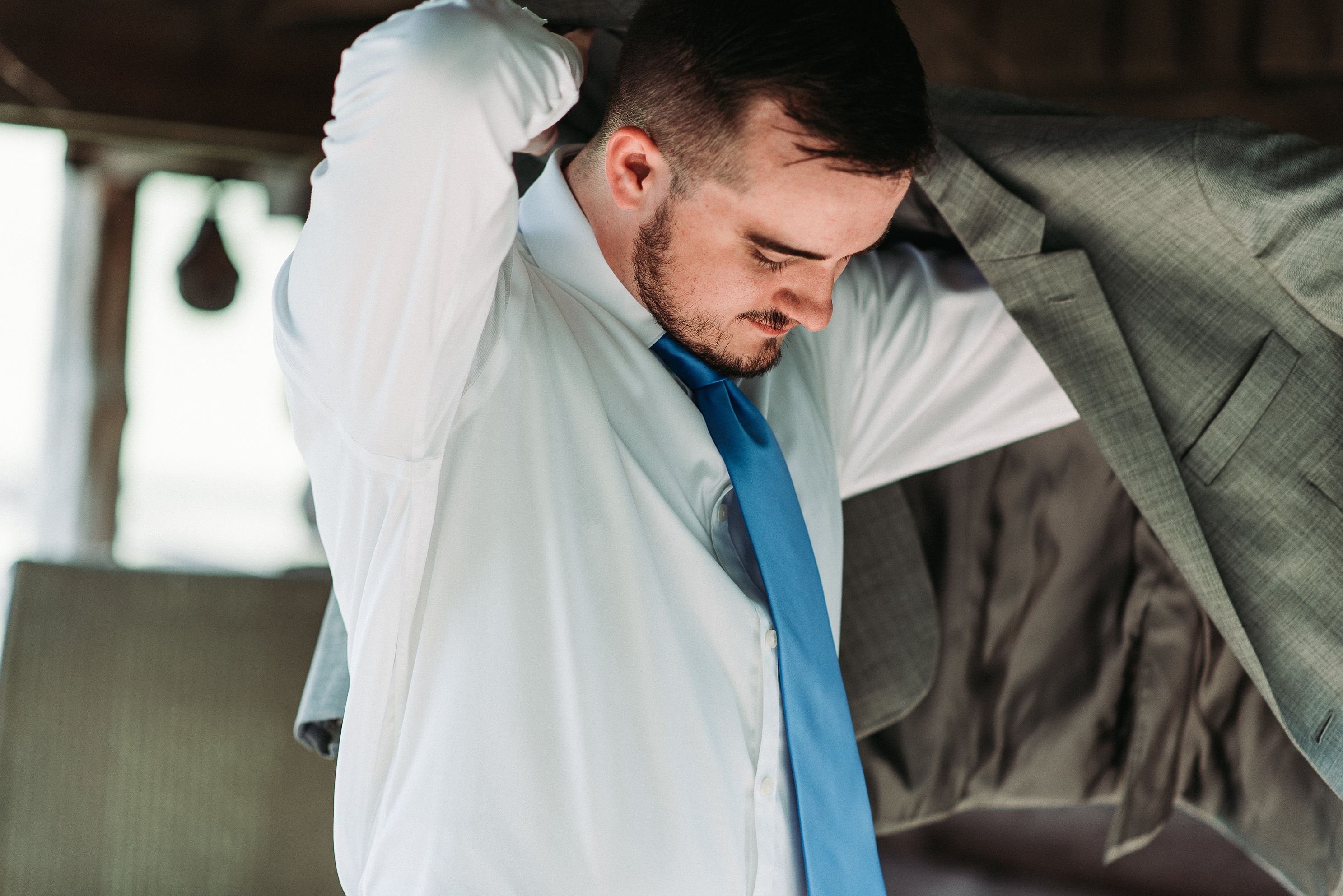 A person puts on a suit jacket.