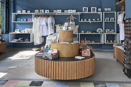 Contemporary retail interior with central wooden display and product shelving