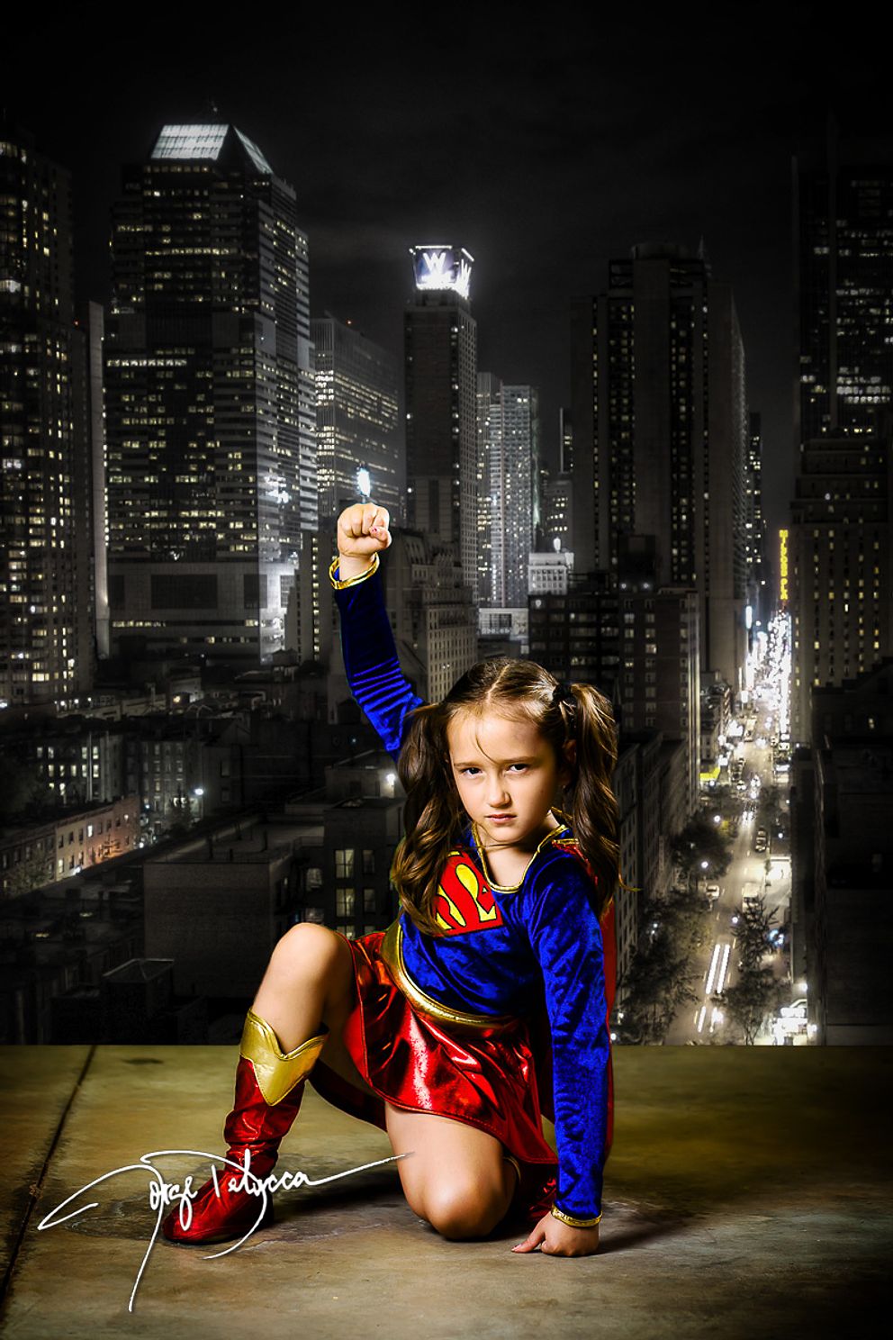 Young girl dressed as Supergirl in a nighttime city scene