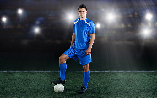 soccer player in front of big modern stadium with flares and lights
