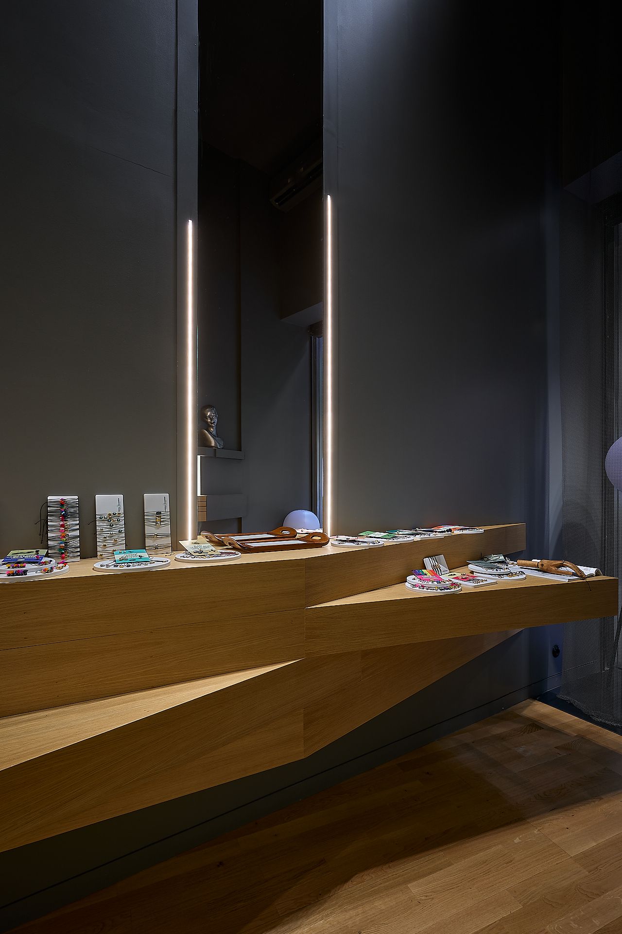 Contemporary jewelry store interior with dark walls and wooden display counters