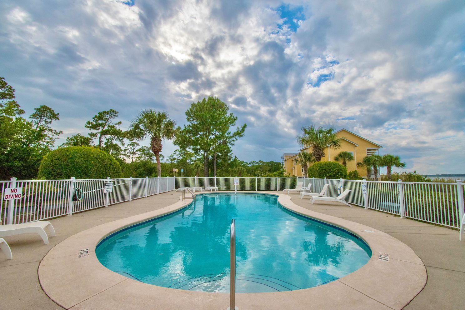 Beautiful swimming pool reflecting the clouds at a townhome community