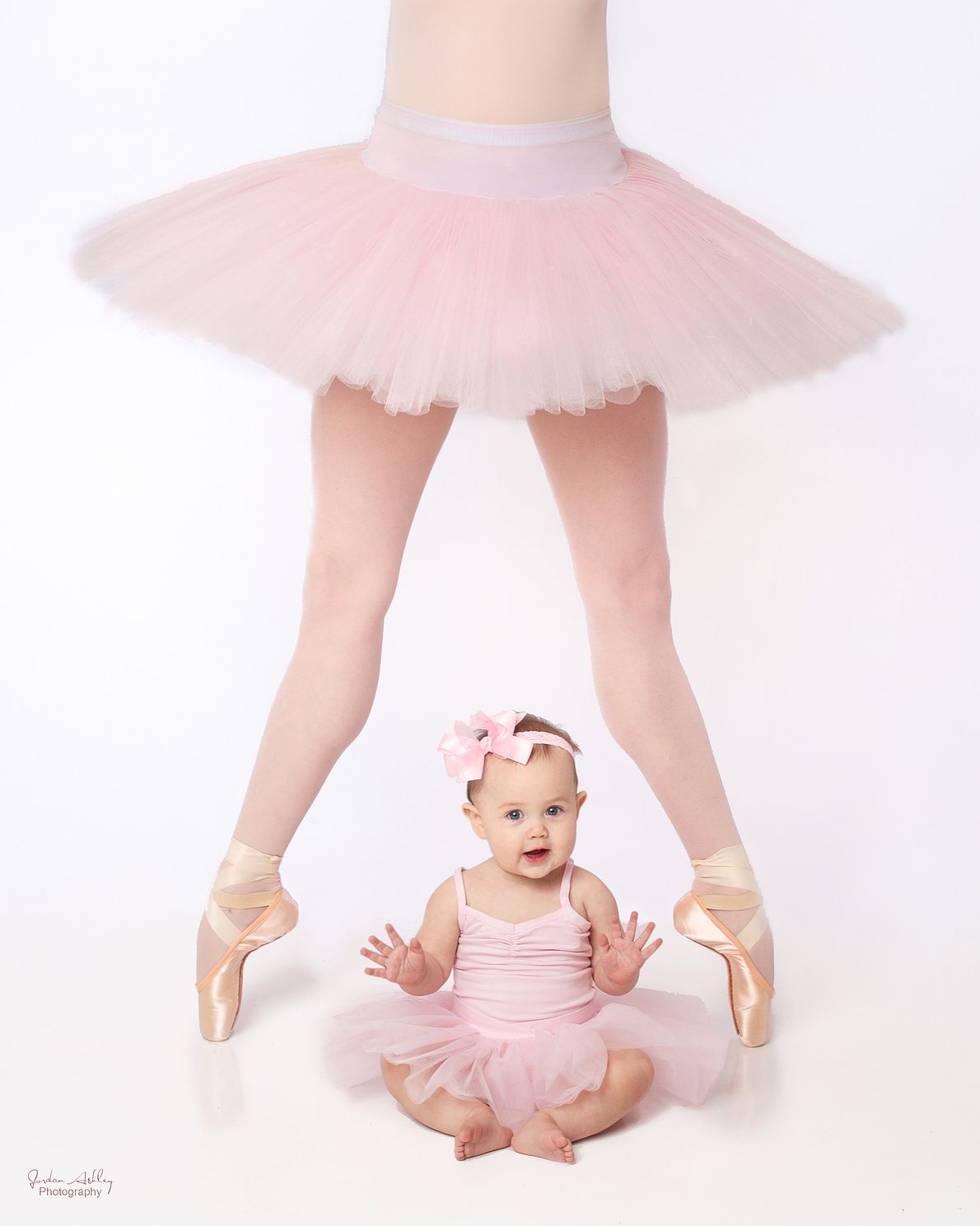 Newborn photo with baby in a tutu and ballerina standing over her.