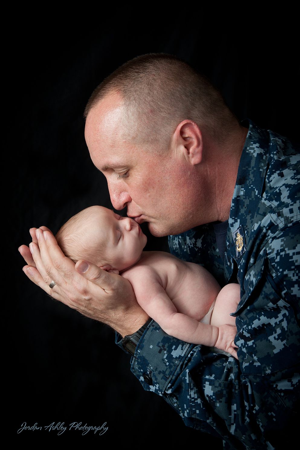 newborn photo with dad kissing baby
