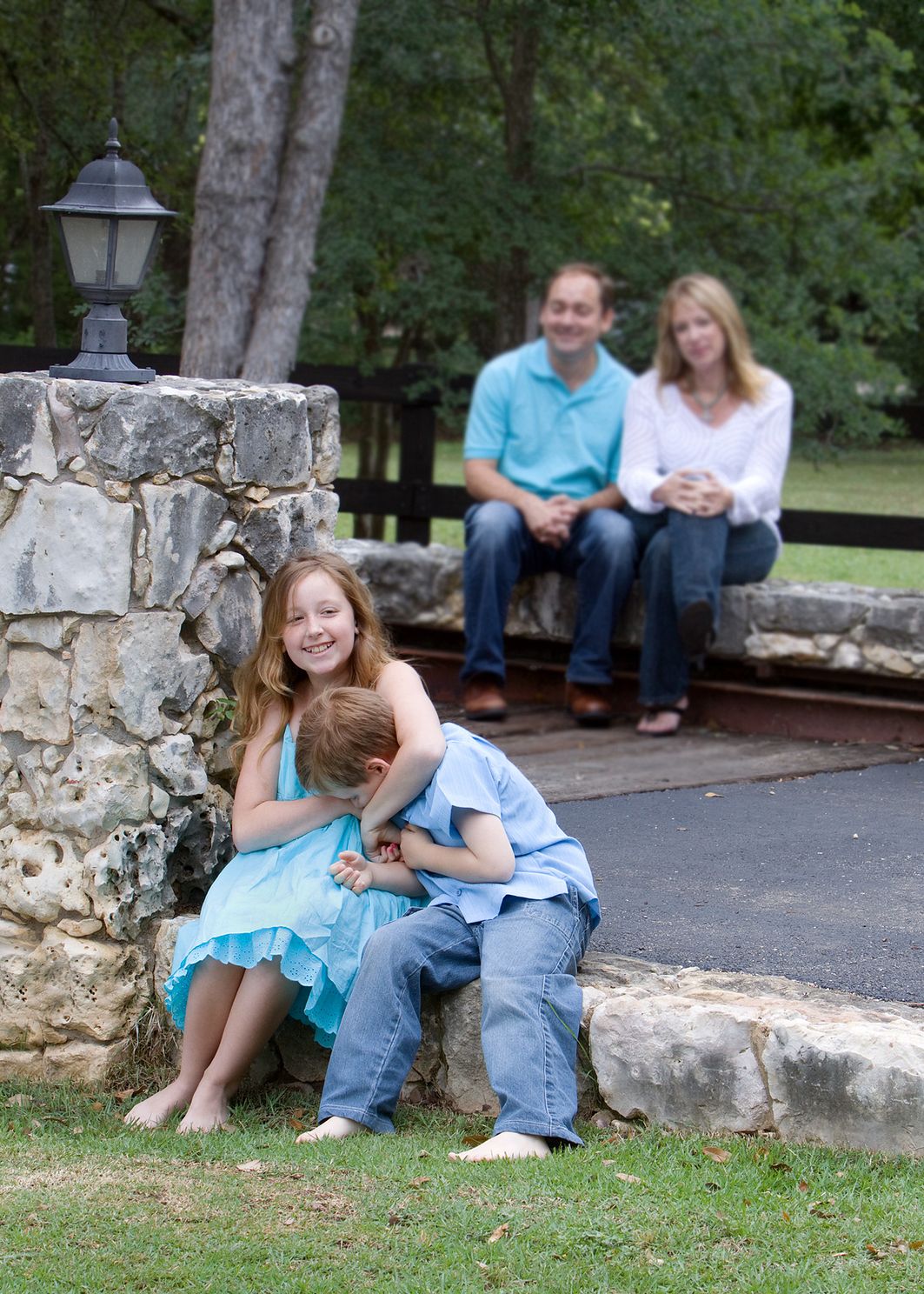 Family photo of parents in background and brother and sister in foreground