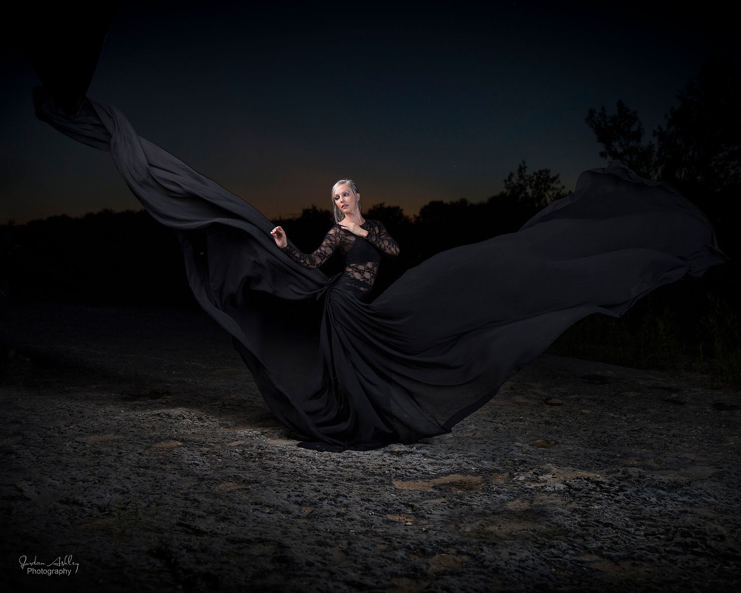 Blond model in flowy black dress at night