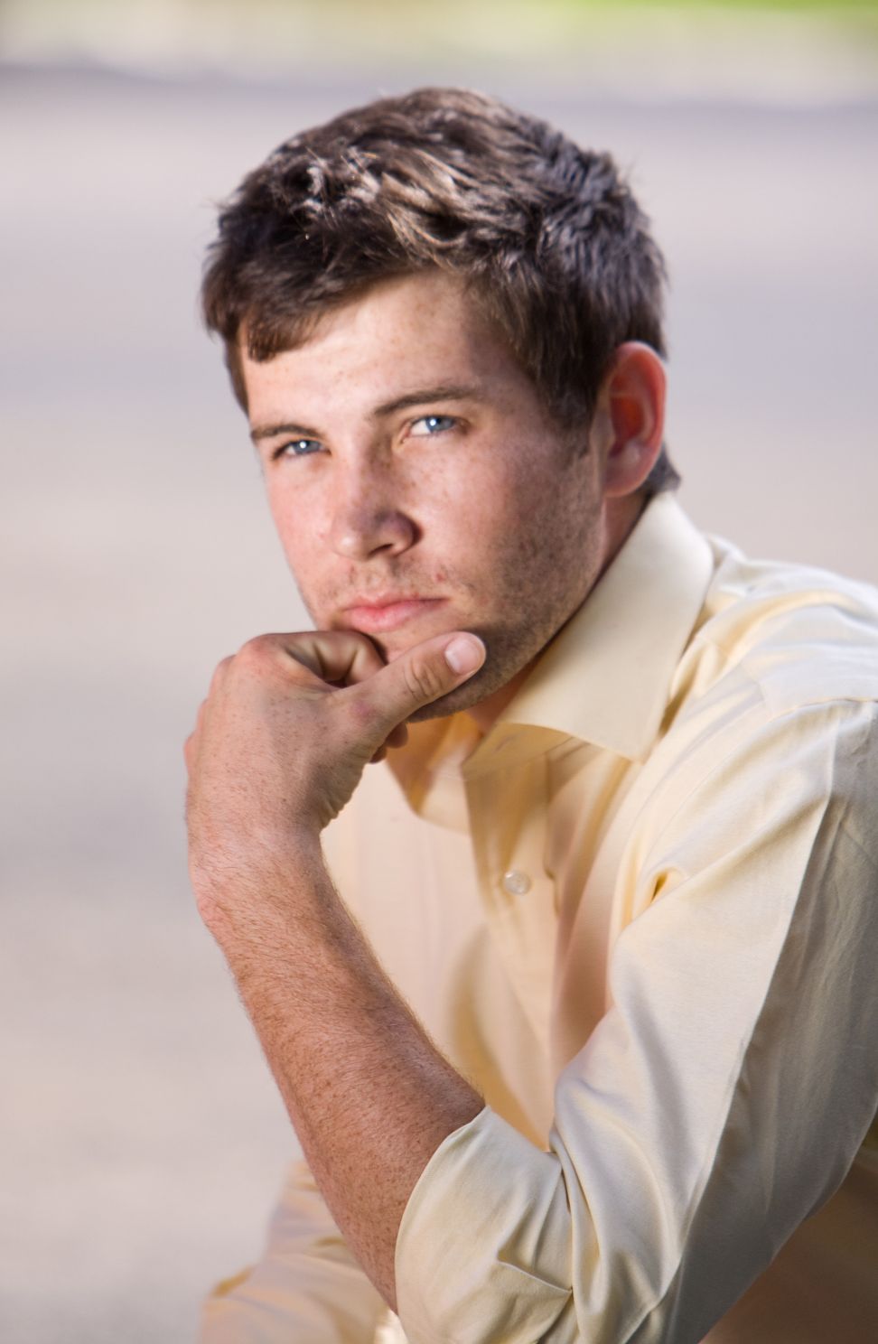 high school portrait of senior with his hand on his chin
