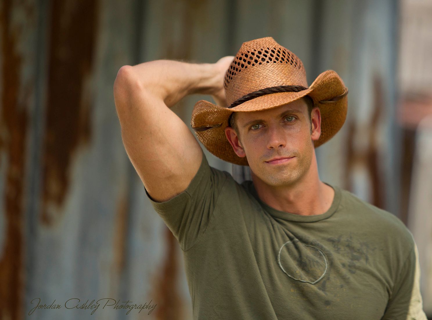 portrait of man in cowboy hat in front of a rustic tin wall in Cedar Park Texas