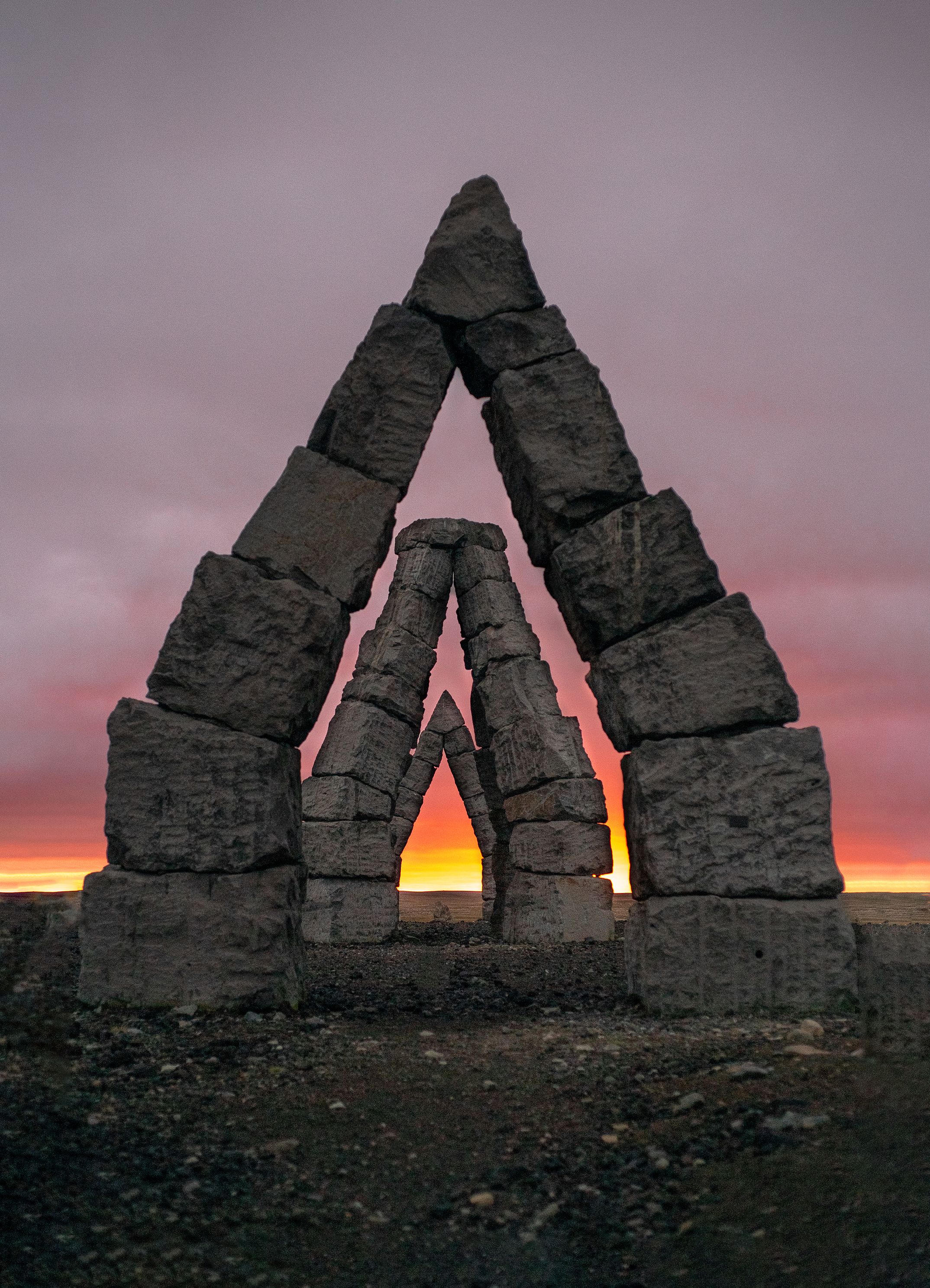 Stones of Arctic Henge in Iceland silhouetted against a vibrant sunset