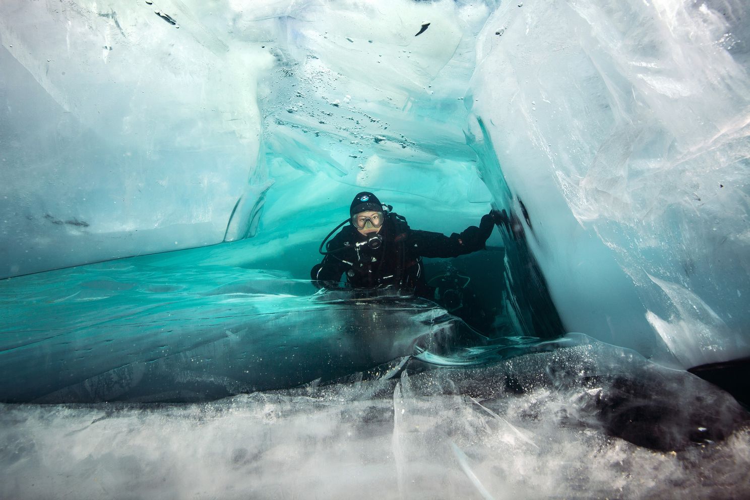 a scuba diver in a cave of ice