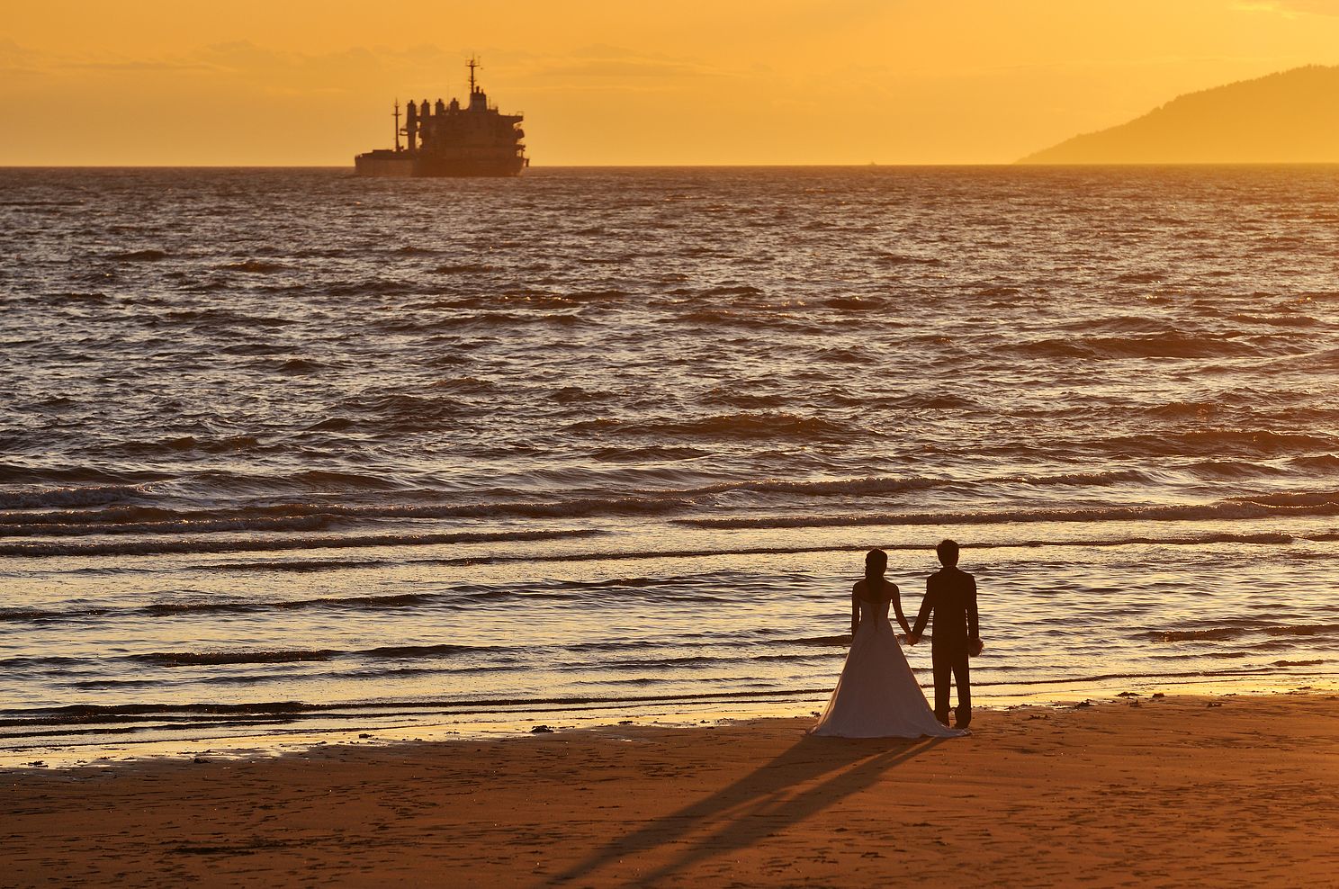 Bride and groom on the beach at sunset