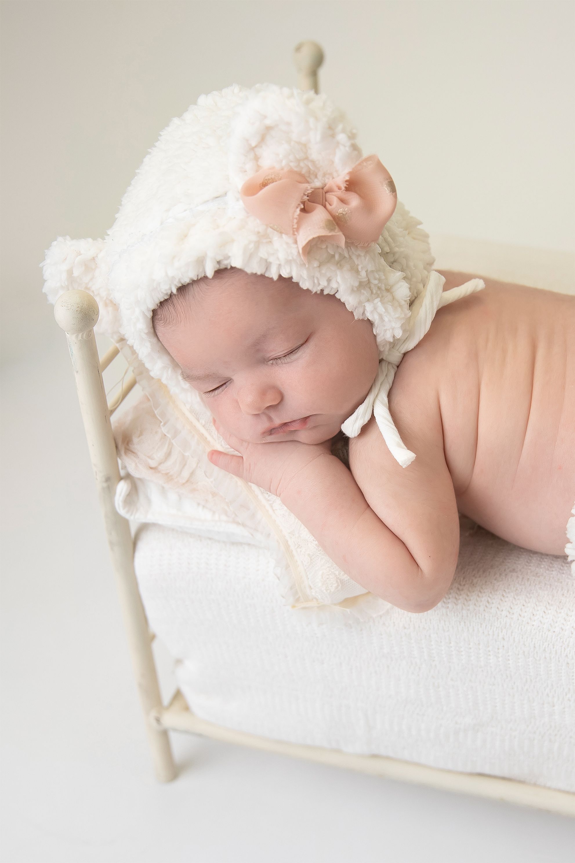 Newborn bed with leg warmers and matching bonnet, white with pink bow, Accredited Photography