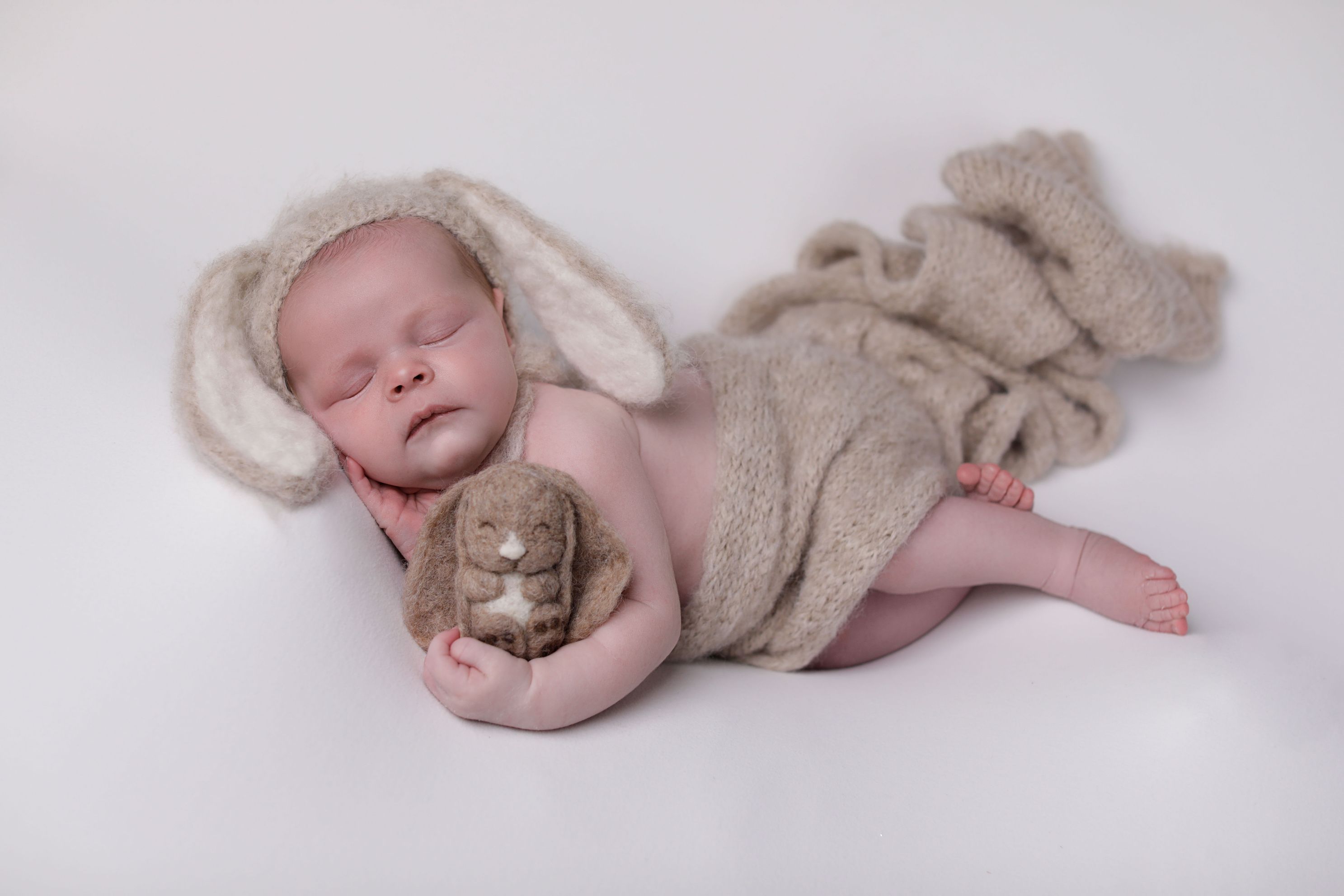 Side pose with bunny ears and lovey, beige wrap, accredited photographer AGK originals props studio