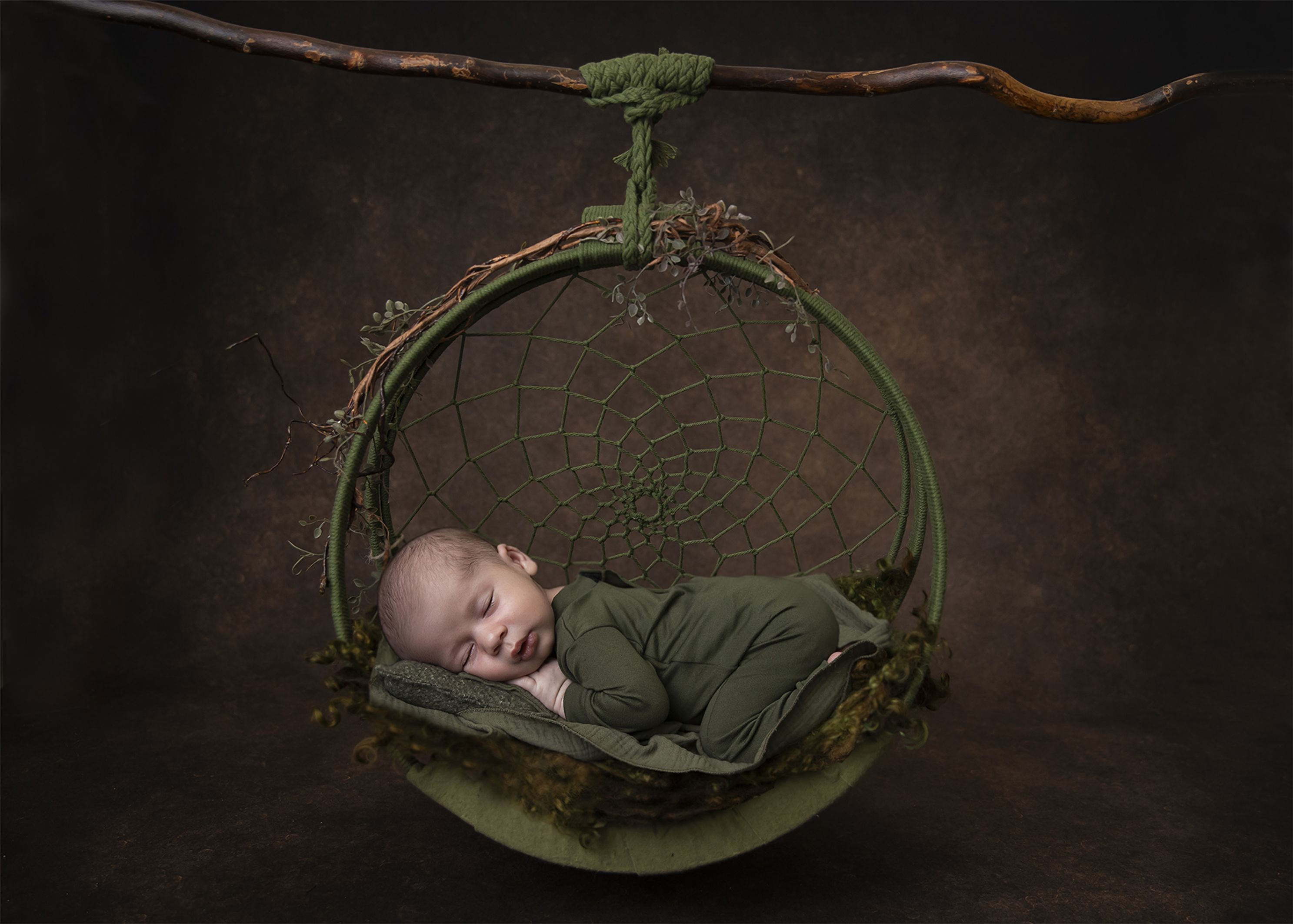 Brown background with Green dreamcatcher in studio image with Green newborn outfit and Green layers