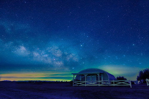 Milky Way at dawn over metal quonset hut