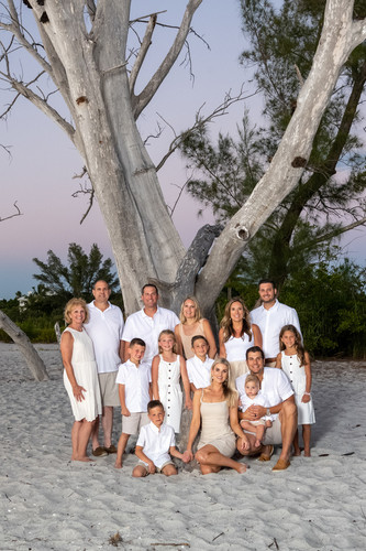large family posing by the tree at Stump Pass on Palm Island