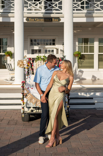 Ben Williams and Bella Hudson smiling in front of the Gasparilla Inn after surprise proposal