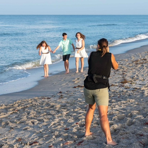 Stephanie photographs three kids as they walk along Englewood Beach during family photo session