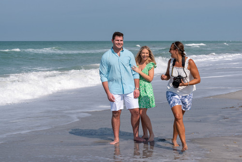 Stephanie laughs with newly engaged couple on the beach before taking their photo